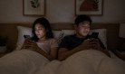 ai-generated-couple-in-bed-with-smartphones.jpeg